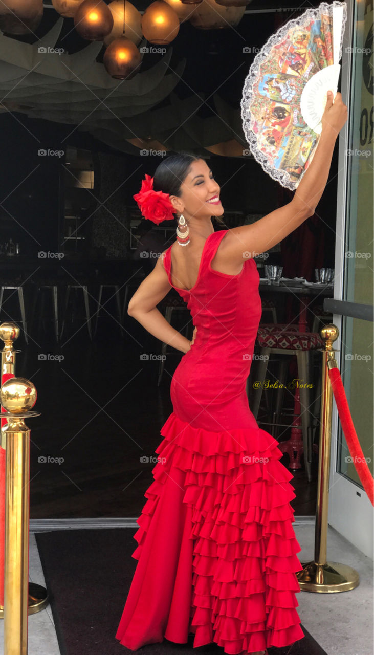 A beautiful Spanish women dressed in a long red dress. 