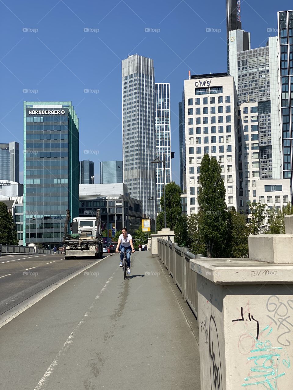 Cyclist in Frankfurt on a bridge over river main - financial district as background 