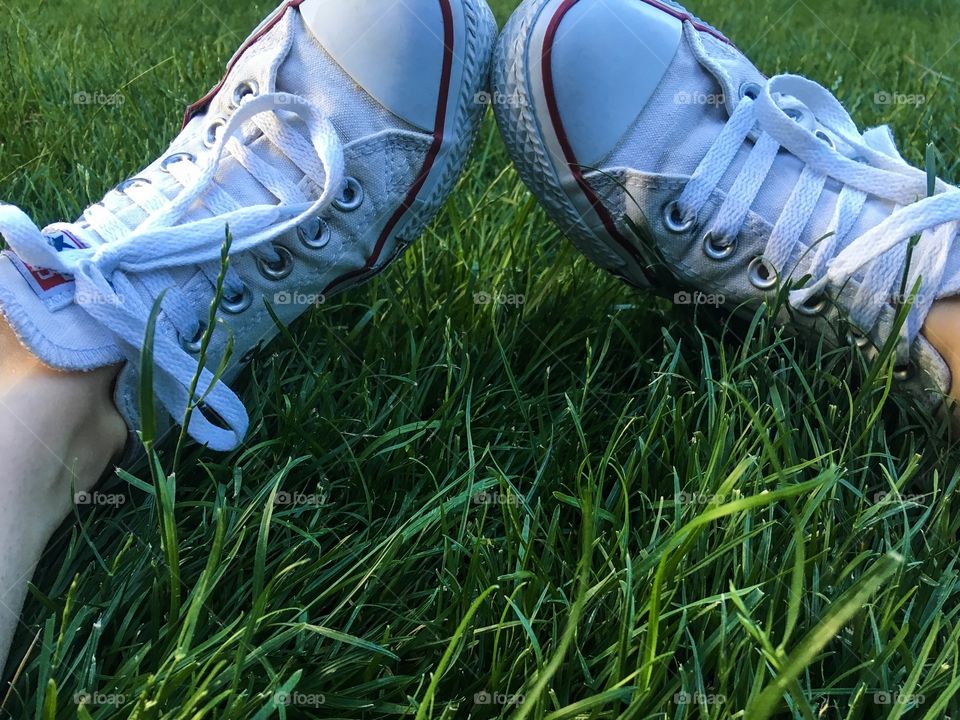The picnic on the the green grass. The white sneakers and green grass background. 