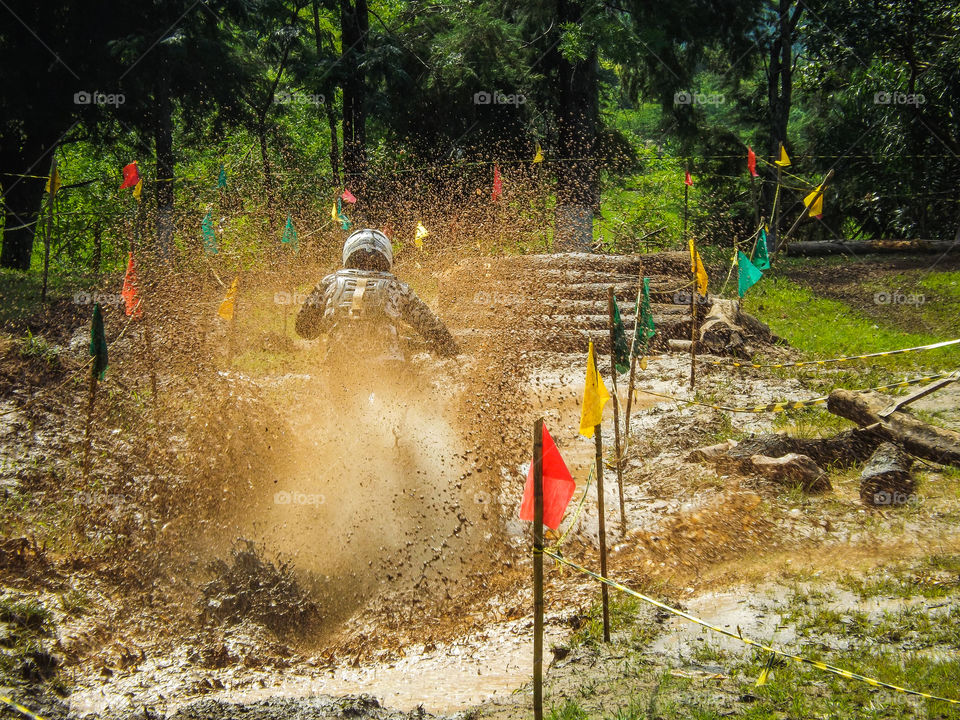 Mud to the top. Motorcycle lifting water and mud up on motocross circuit.