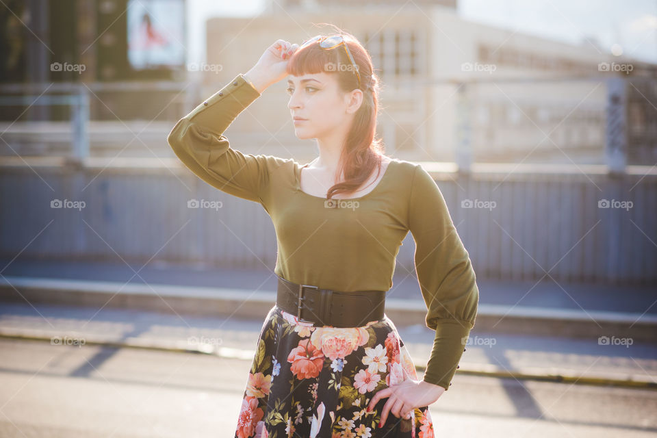 Portrait of a stylish woman posing in the city during sunset