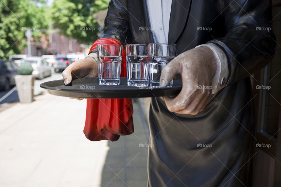 statue of awaiter at the entrance of a restaurant . Restaurant and cafe concept .