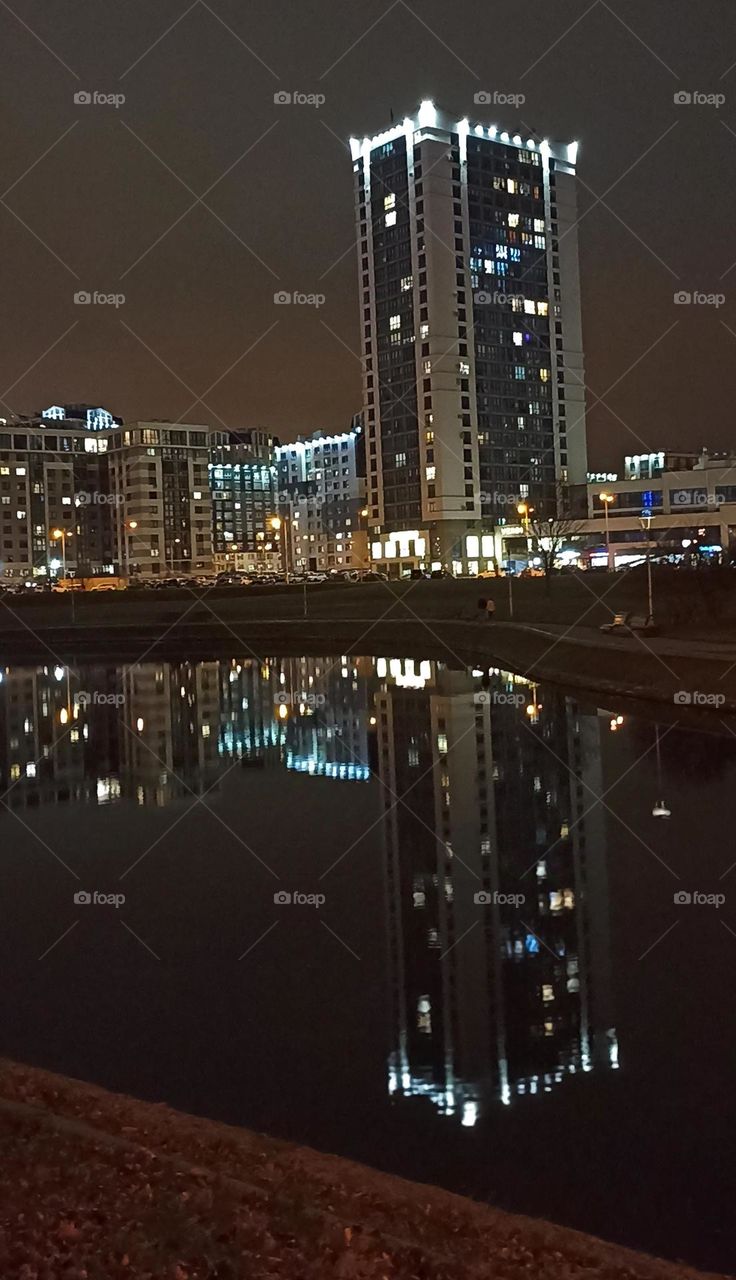 beautiful night light city windows home and reflection in water