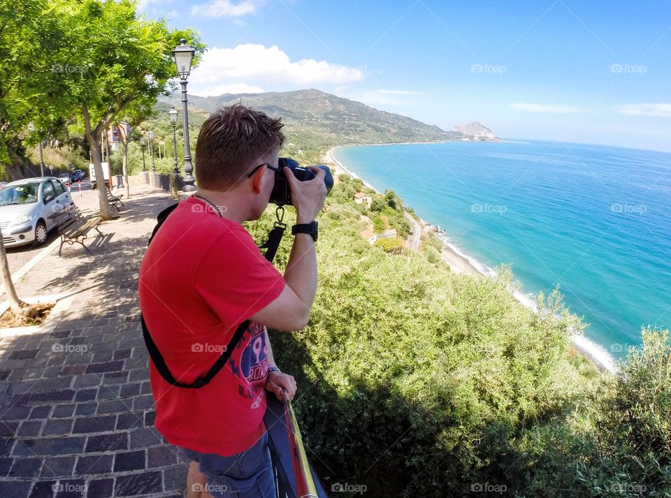 Tourist taking pictures of nice view in Cefalu on Sicily.