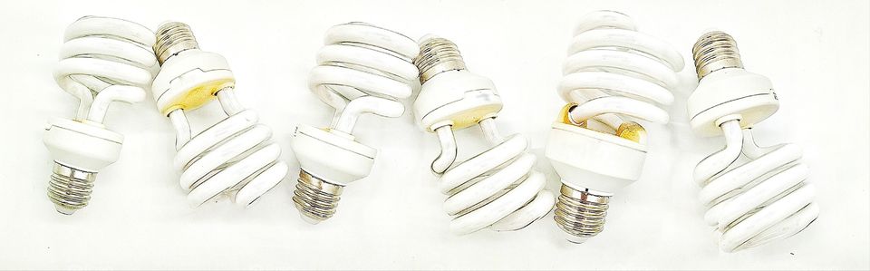 six energy-saving light bulbs lined in a row on a white background