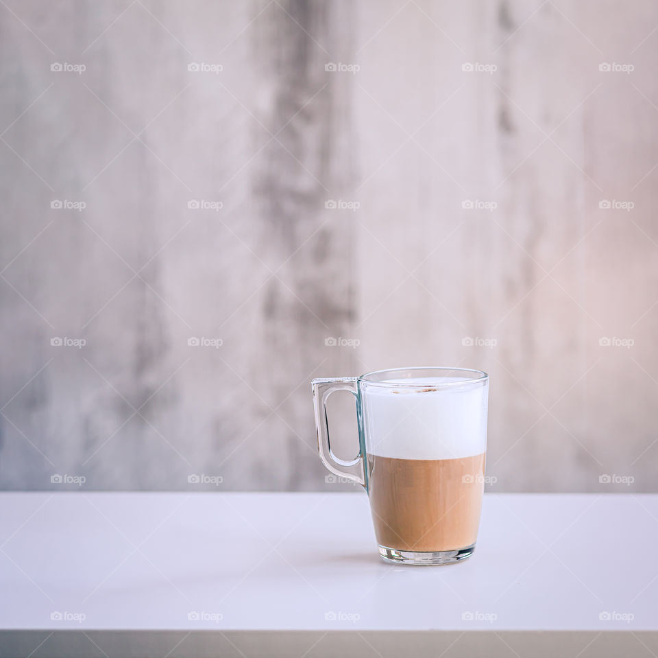 Glass with caffe latte on the table with copy space.
