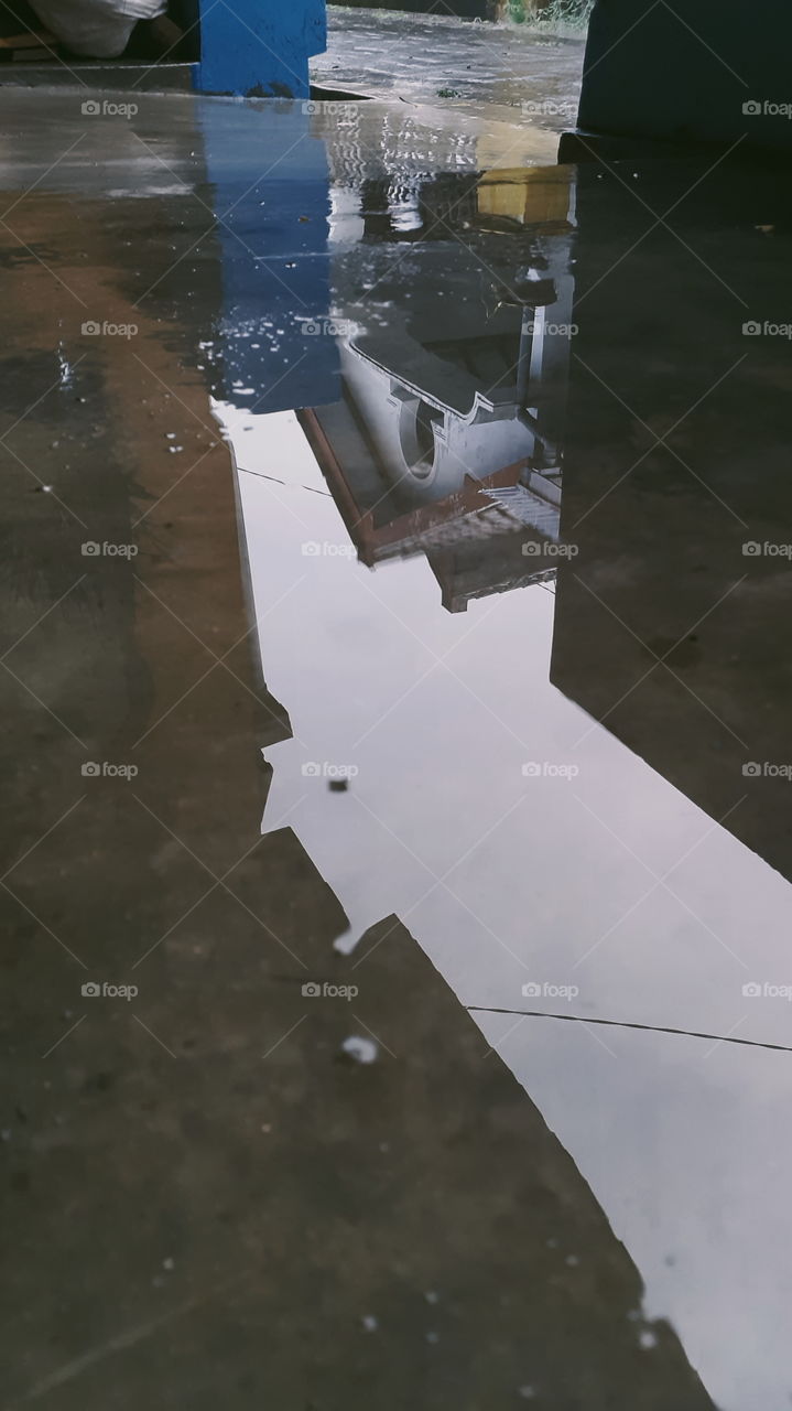 A reflection of house in the puddle after rain.