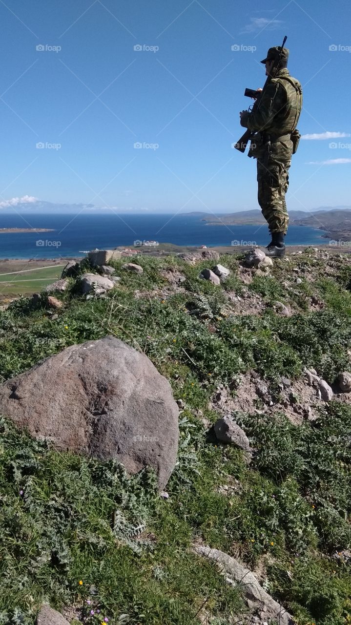 A greek dedicated soldier looking at the fantastic view of the sea so close to the Turkish Greek border