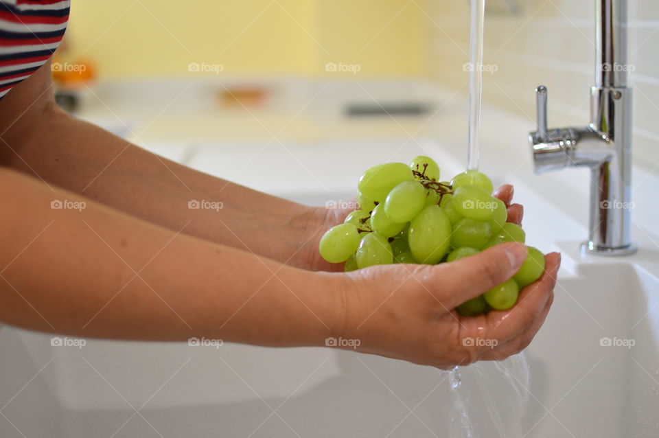 Woman’s hands rinsing grapes 