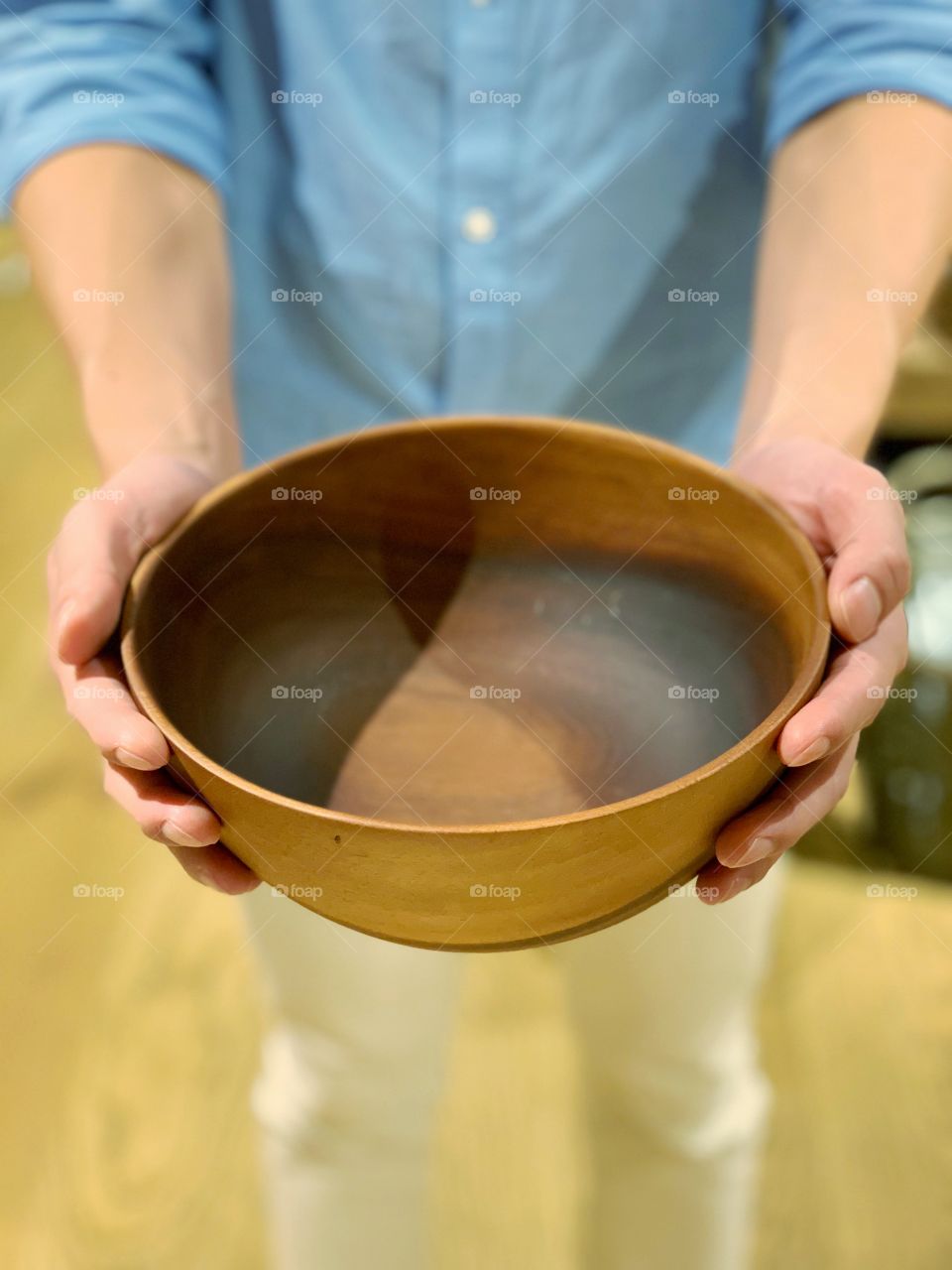 Man holding empty wooden bowl