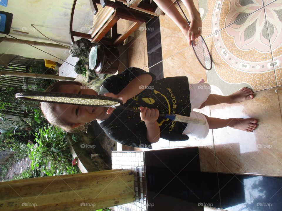 Little girl is playing with a racket