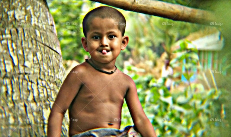 A little kid. He is a Bangladeshi boy. We are seeing him in an innocent look. He is also an innocent boy..!!
