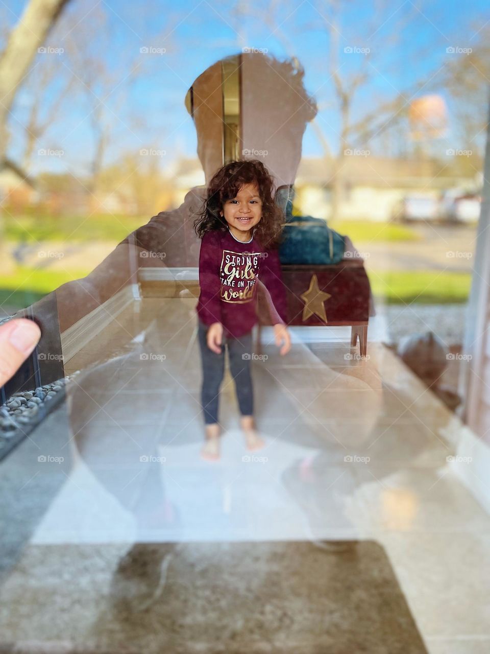 Reflection of mother in window with toddler inside home, mother looks in from the front porch, looking into your house, toddler girl sees mother through window, toddler girl sees mother outside, reflections of spring and mother with focus on toddler