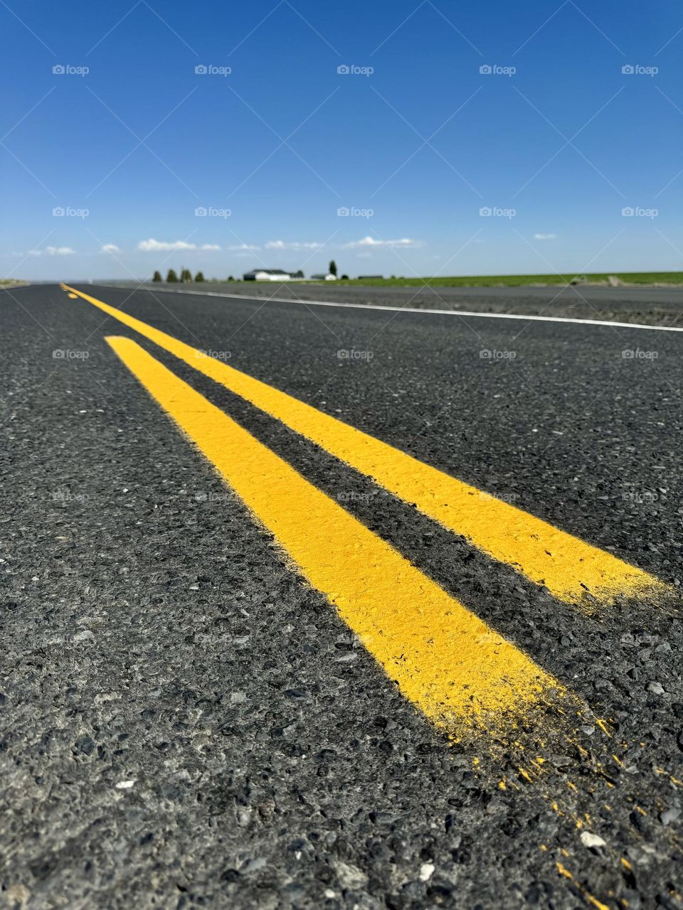 Yellow lane on the empty road going to horizon 