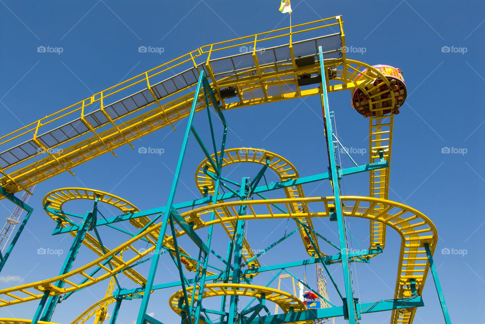 Yellow roller coaster. Image of a yellow roller coaster against a blue sky