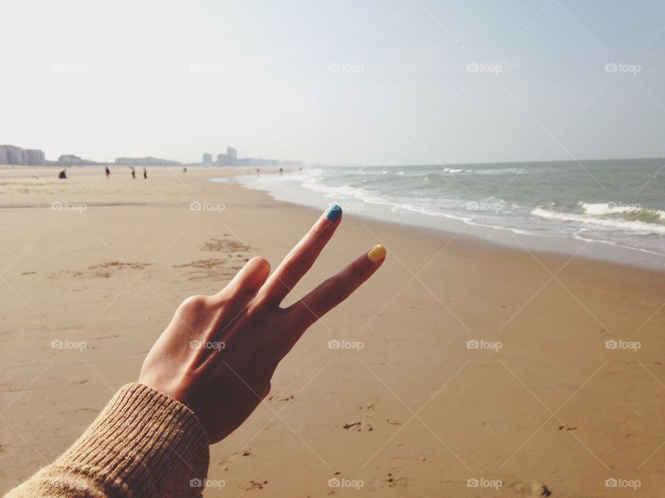 Fingers Peace at wide beach 