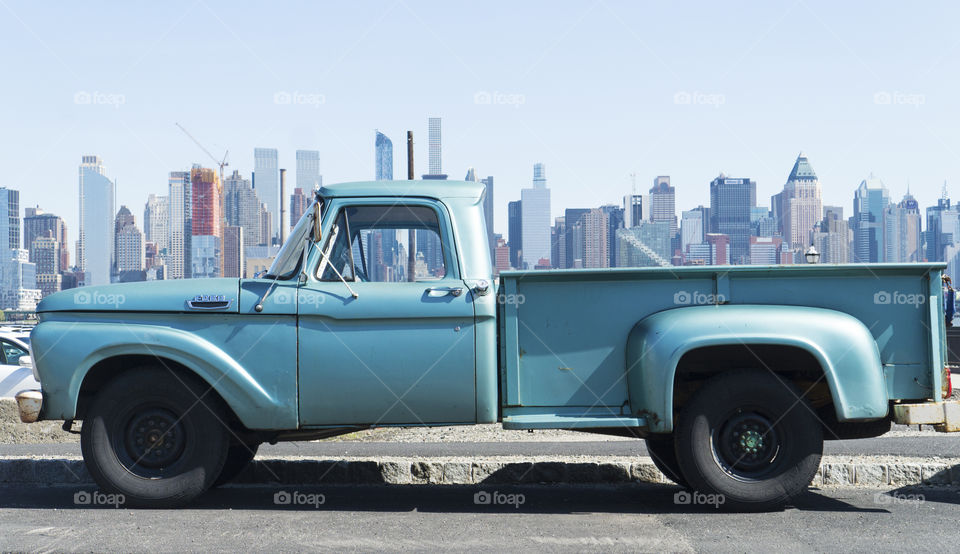 A vibrant blue truck with the New York skyline in background