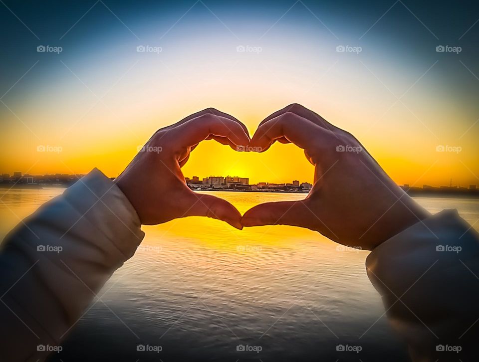 hand heart shape at sunset