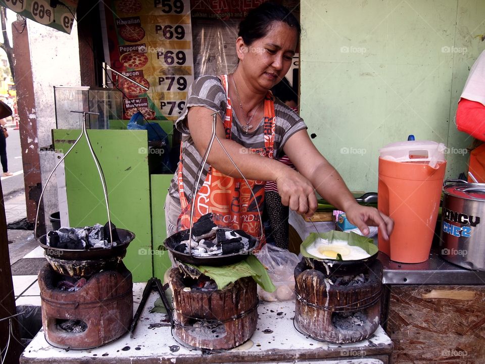 street food vendor. street food vendor cooking bibingka or rice in antipolo city in the philippines, asia