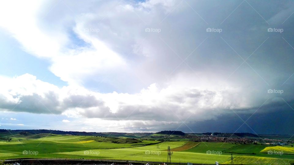 landscape of a green field and clouds