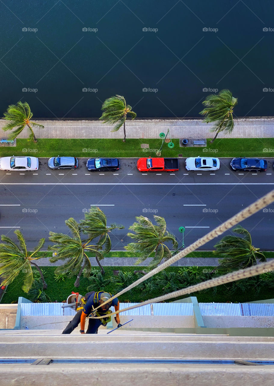 Window washer on a high-rise building seen from above 