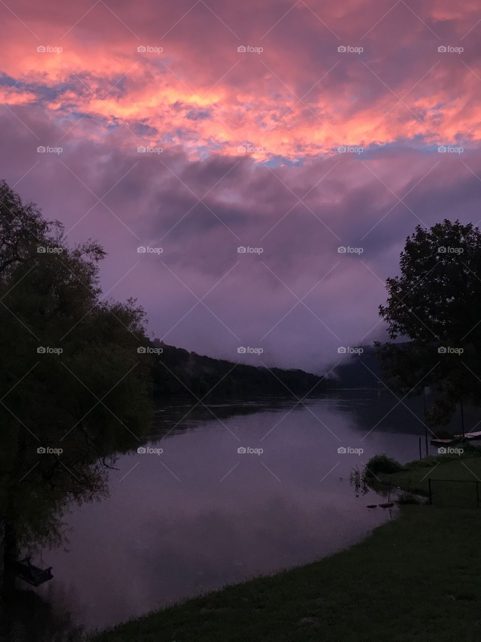 Sunset glowing clouds over river 