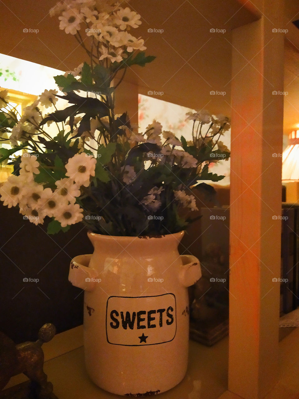White jug with a bouquet of artificial flowers