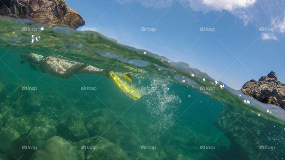 Over and under snorkeler in Carribean water