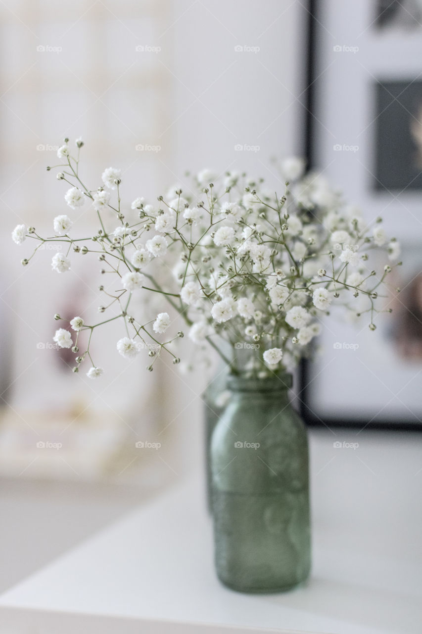 White flowers in a small green vase