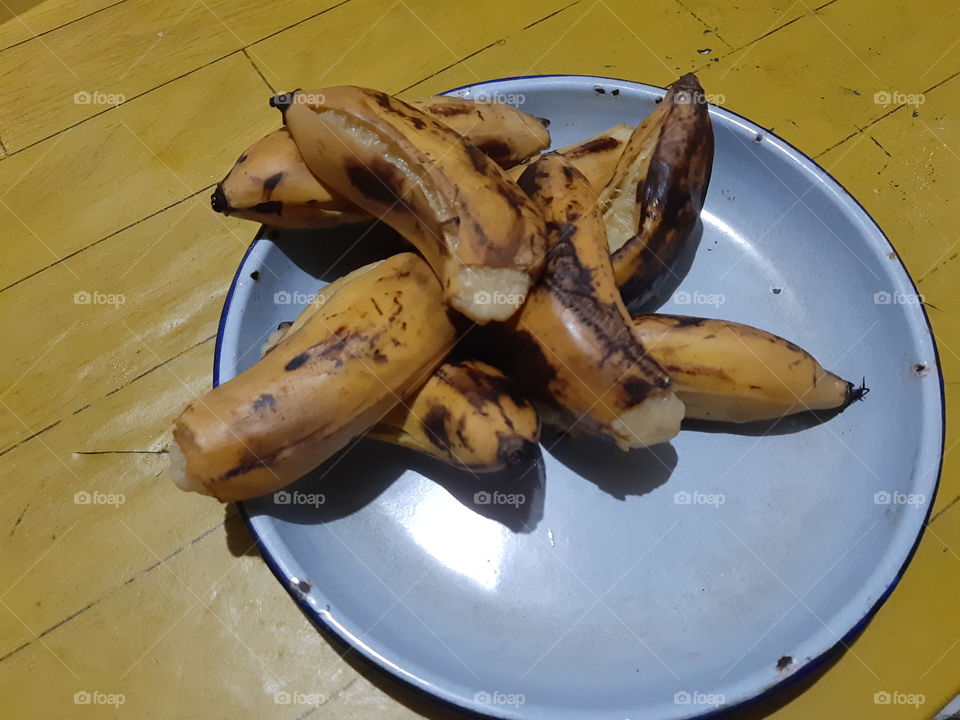 A piles of steamed bananas on a blur round plate.This is a local food in Bali and very delicious.