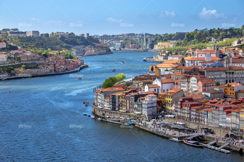 Porto (Portugal) city downtown and Douro river. Porto is known for its stately bridges and port wine production as well as Ribeira (riverside district on right side of photo) with narrow cobbled streets wind past merchants houses and cafes