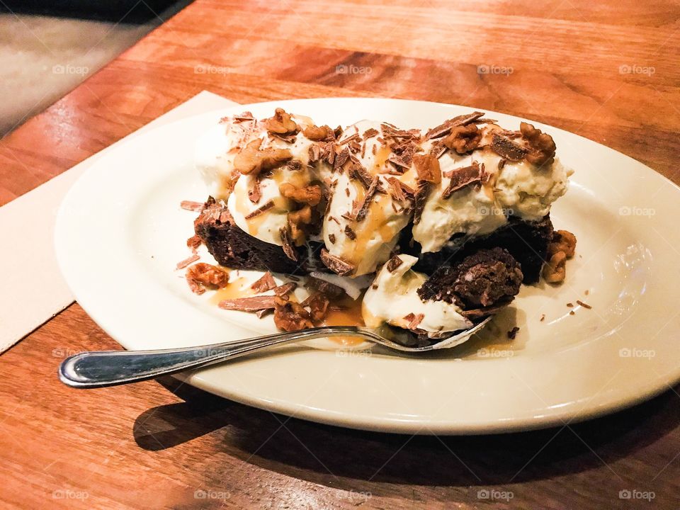 Warm chocolate brownies with ice cream & whipped cream topped with caramel sauce, chocolate shavings and toasted walnuts. Yummy! 😋