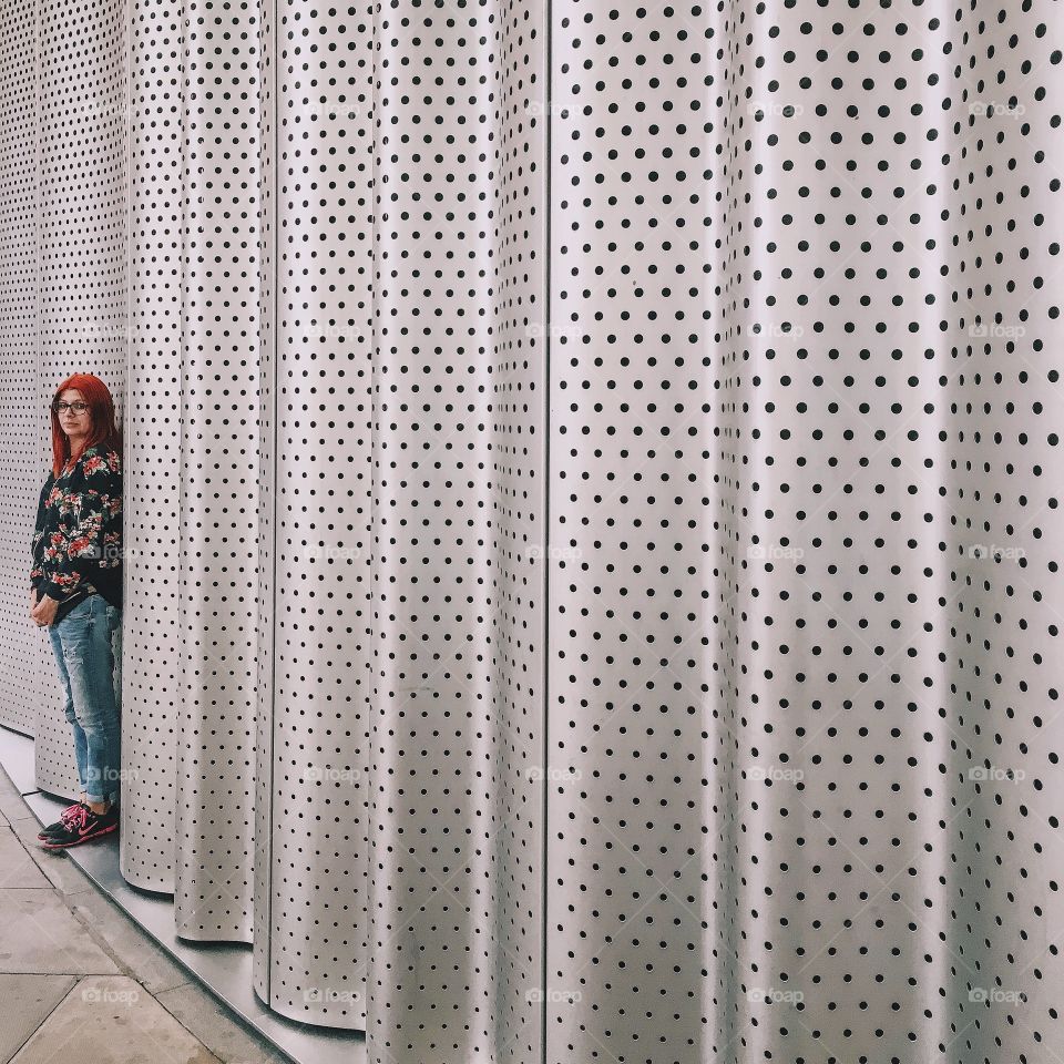 Woman standing near the aluminum wall