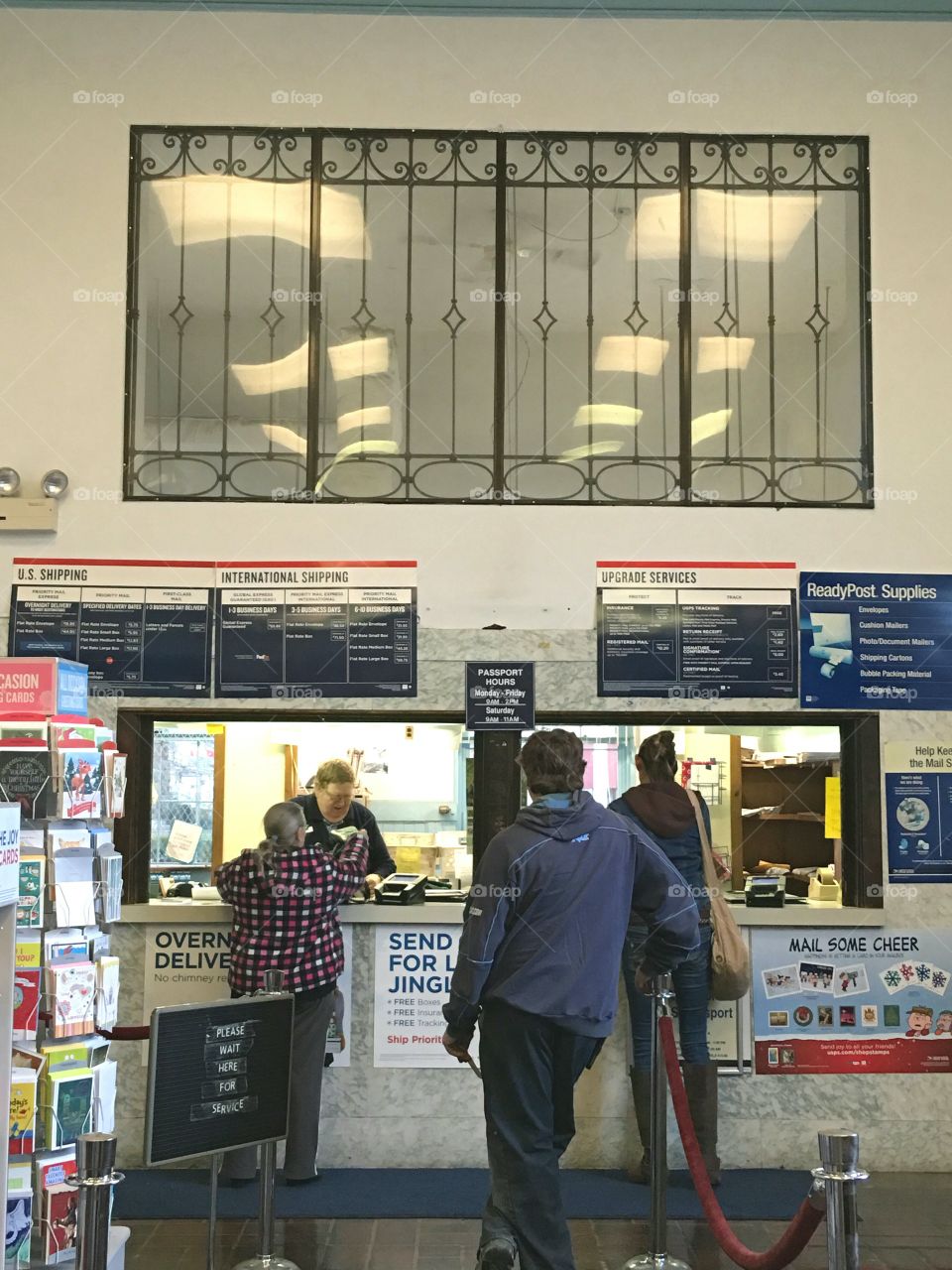 Town Post Office, people in line for stamps, passports, mailing packages & checking mailboxes. Located in New England.