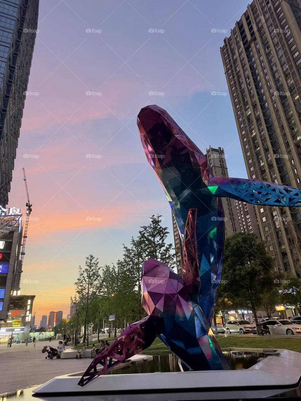 The whale-shaped art installation gleams and shines amid the city as dusk falls.