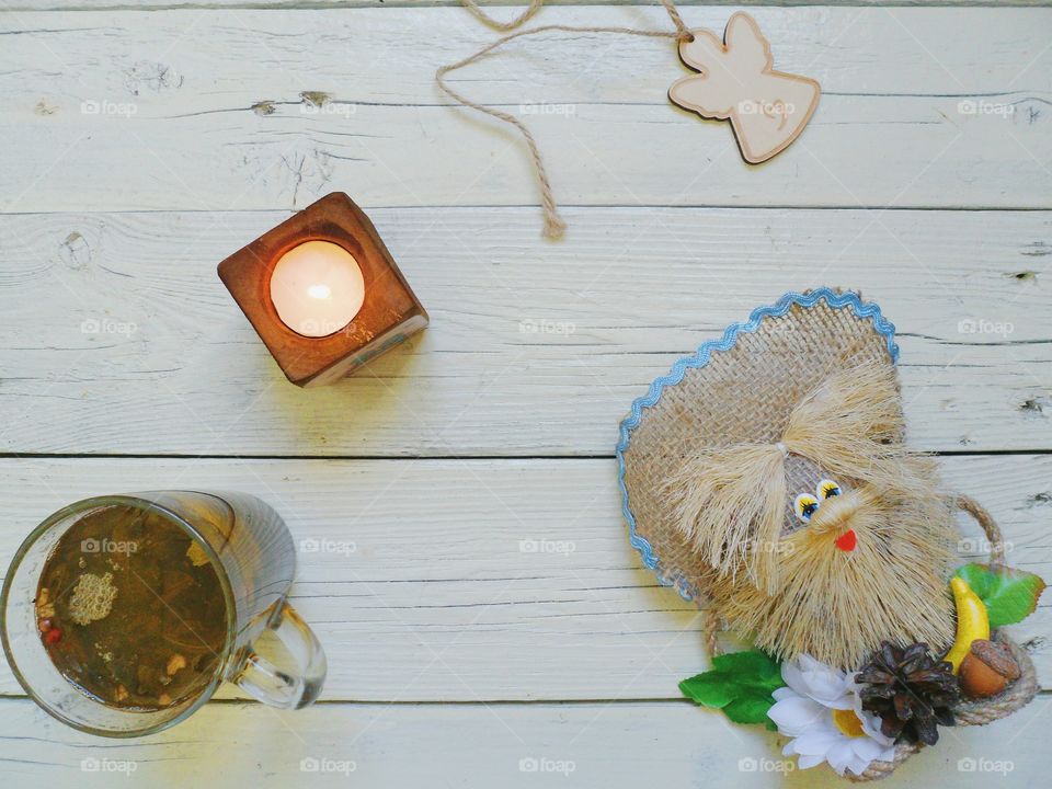 cup of tea, crafts, candle and an angel on the table