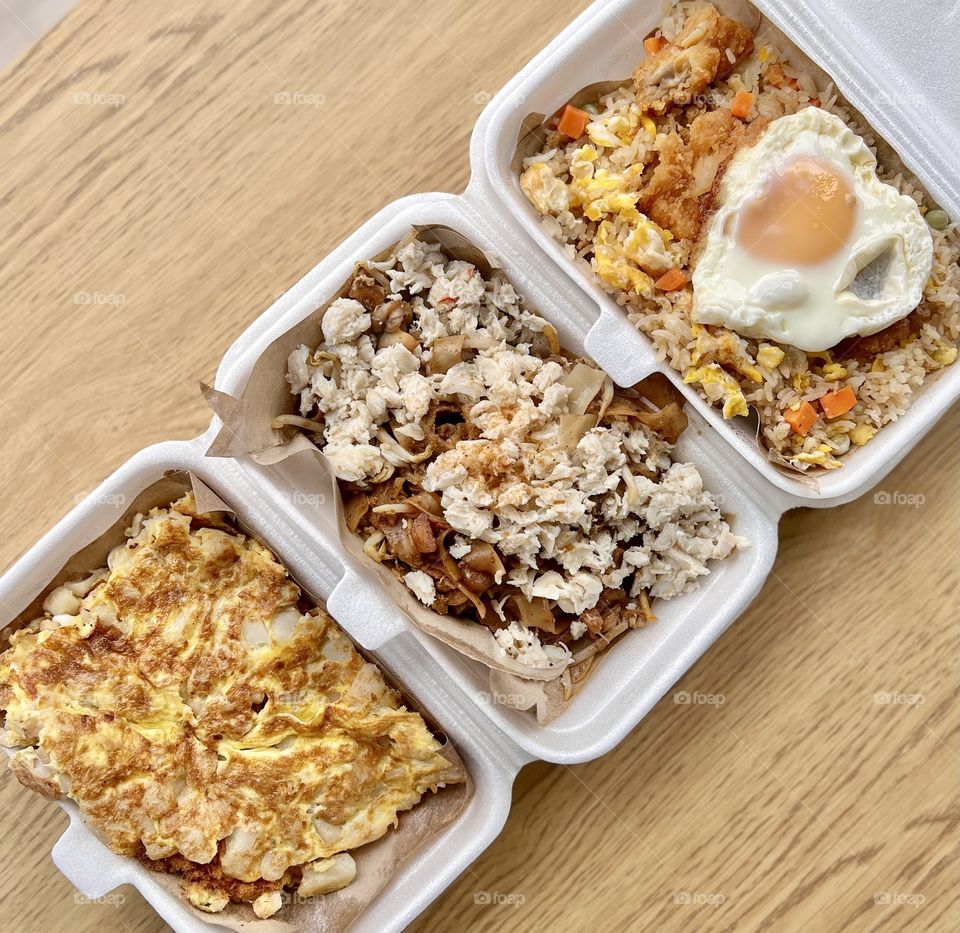 Local hawker asian dishes in cheesy floss carrot cake, crab meat char kway teow and fried rice with chicken and egg
