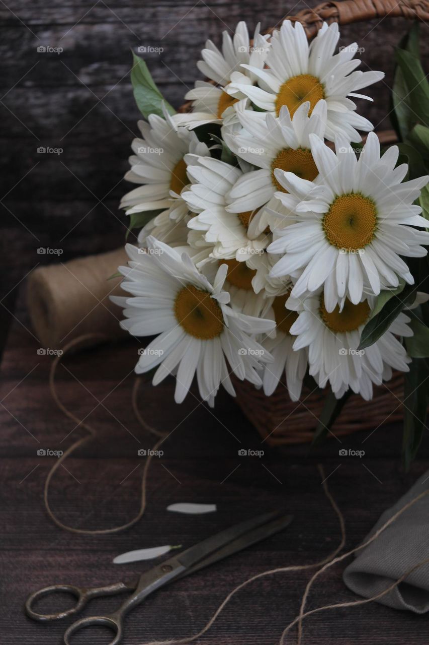 Daisies in a basket on the table