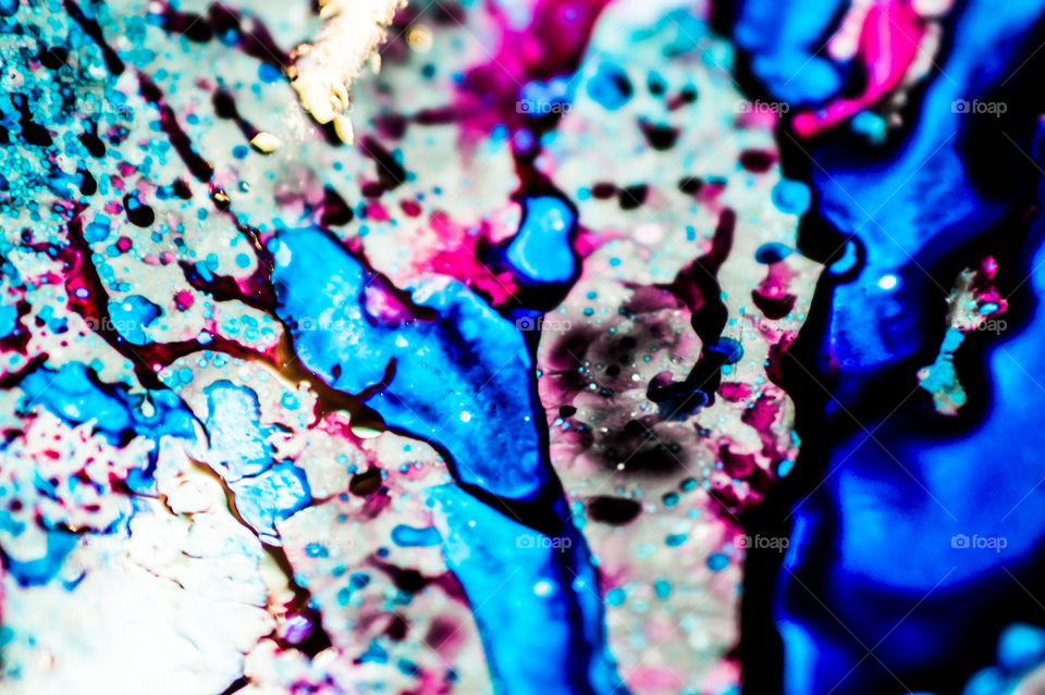 The ink to refill the printer cartridge was spilled onto the white washbasin and the paints blended into abstract drips and patterns.