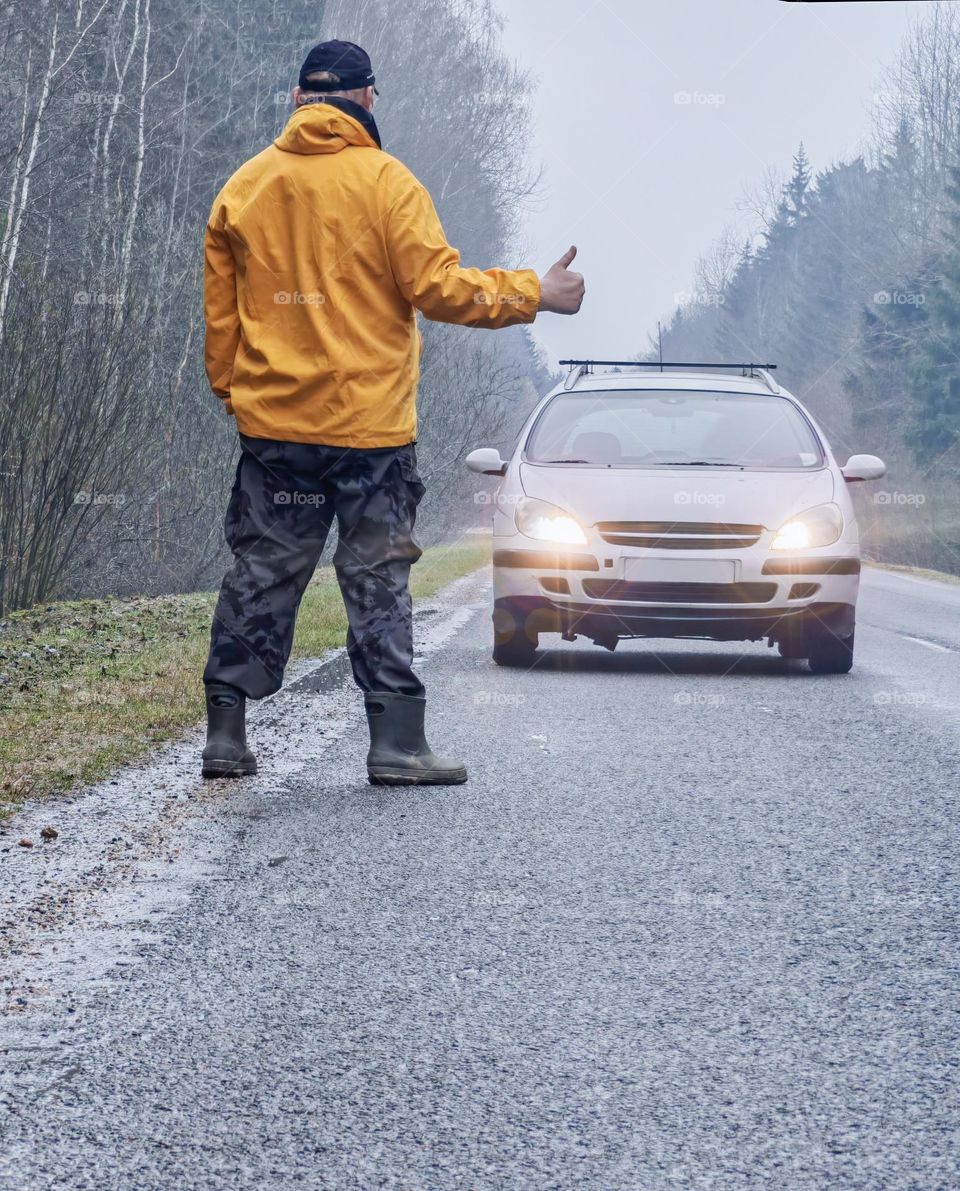 A man slows down a car on the road