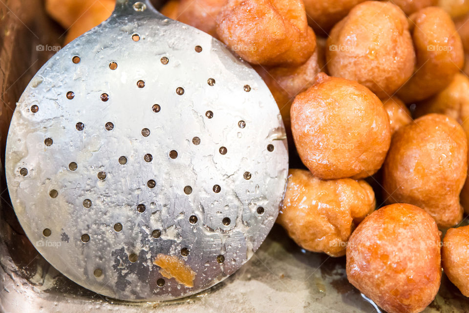 Metal Skimmer And Greek Loukoumades Donuts With Honey
