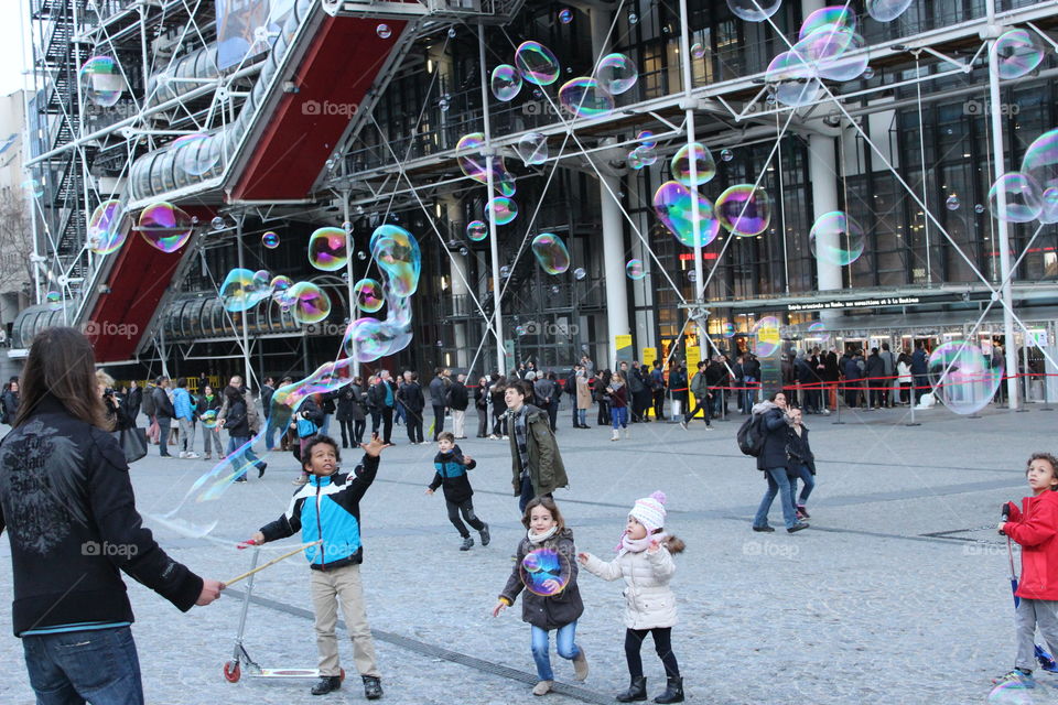 Happy children are playing with the bubble balls in the pompdou centre at Paris