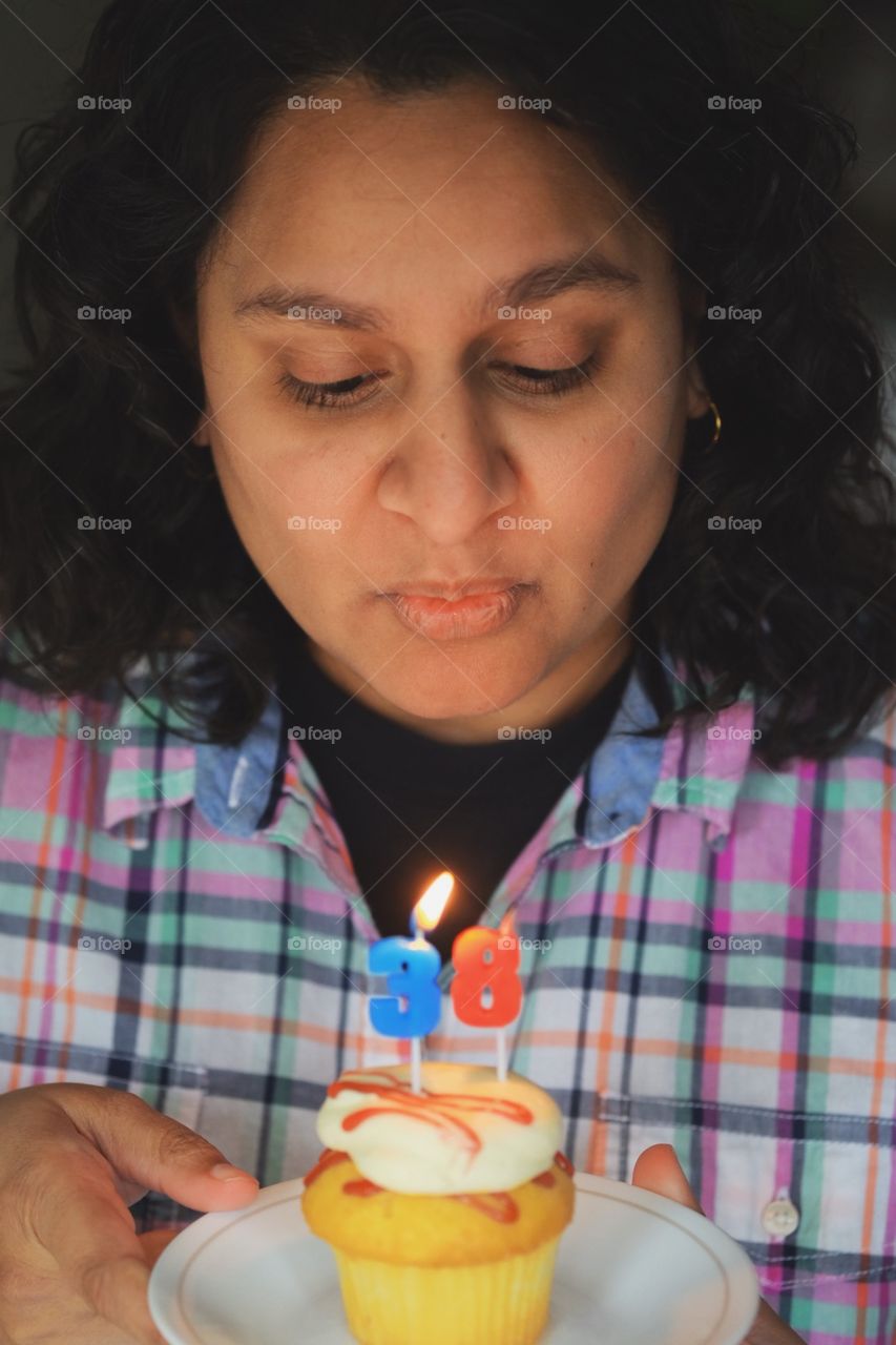 Woman blowing out birthday candles, birthday party for a girl, quarantine birthday, 38 years old, celebration frozen, freezing action, blowing out birthday candles 