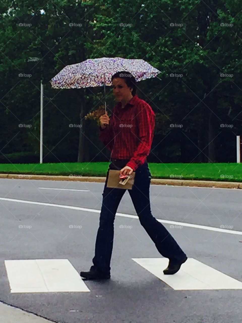 Woman waking in light rain umbrella 