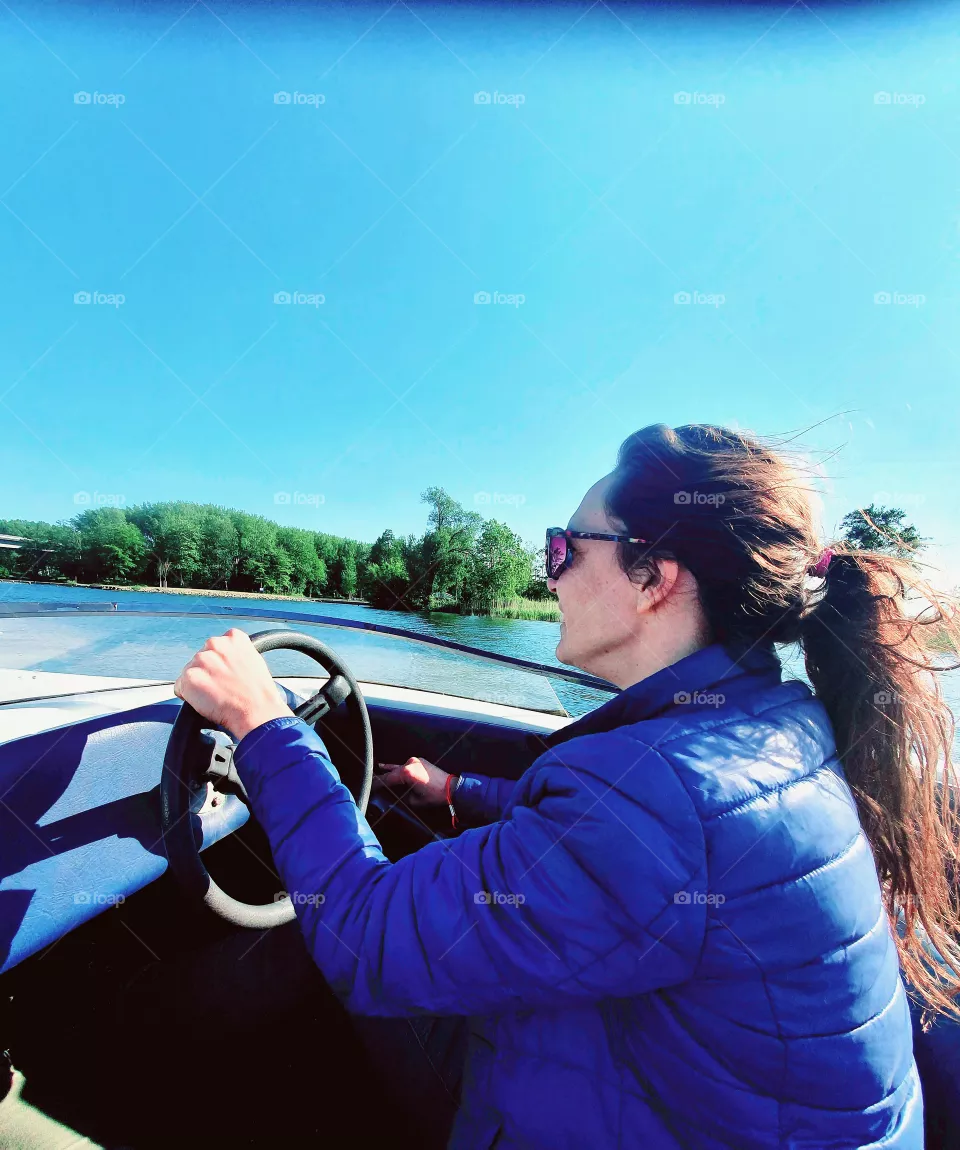 Woman speeds speedboat.