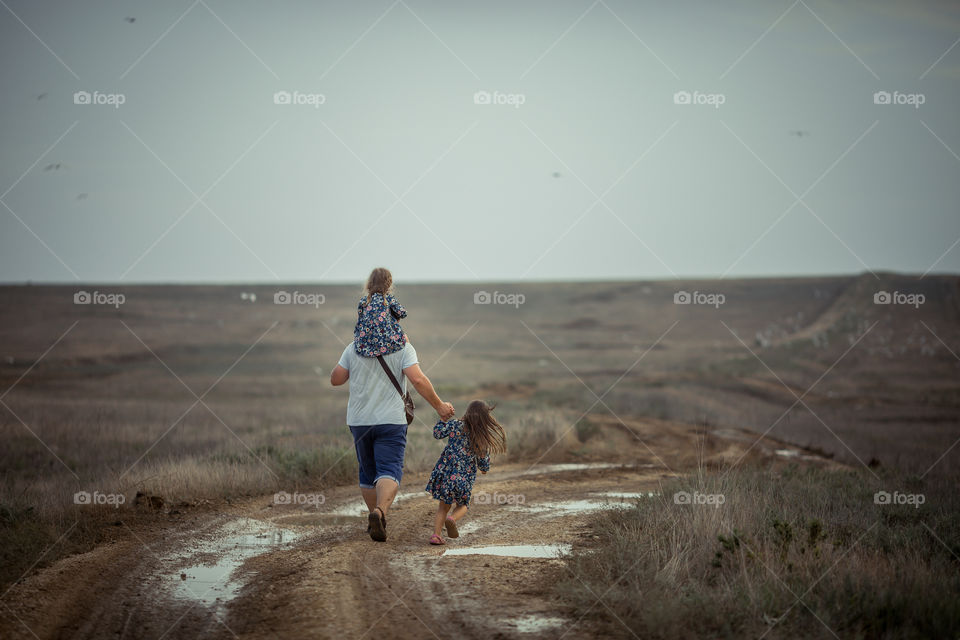 Father with two daughters walking outdoor 