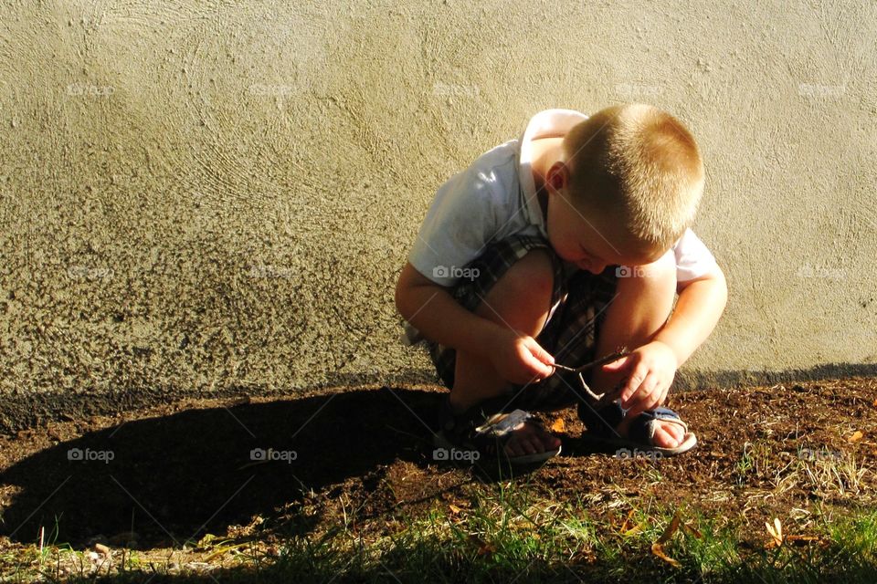Little boy checking the dirt.