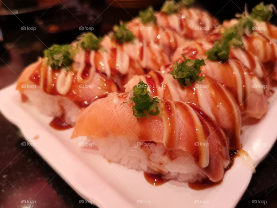 close-up of burned salmon sushi on white plate. Japanese's food.