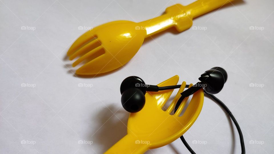 Yellow forks Trying to grab some music with earphones