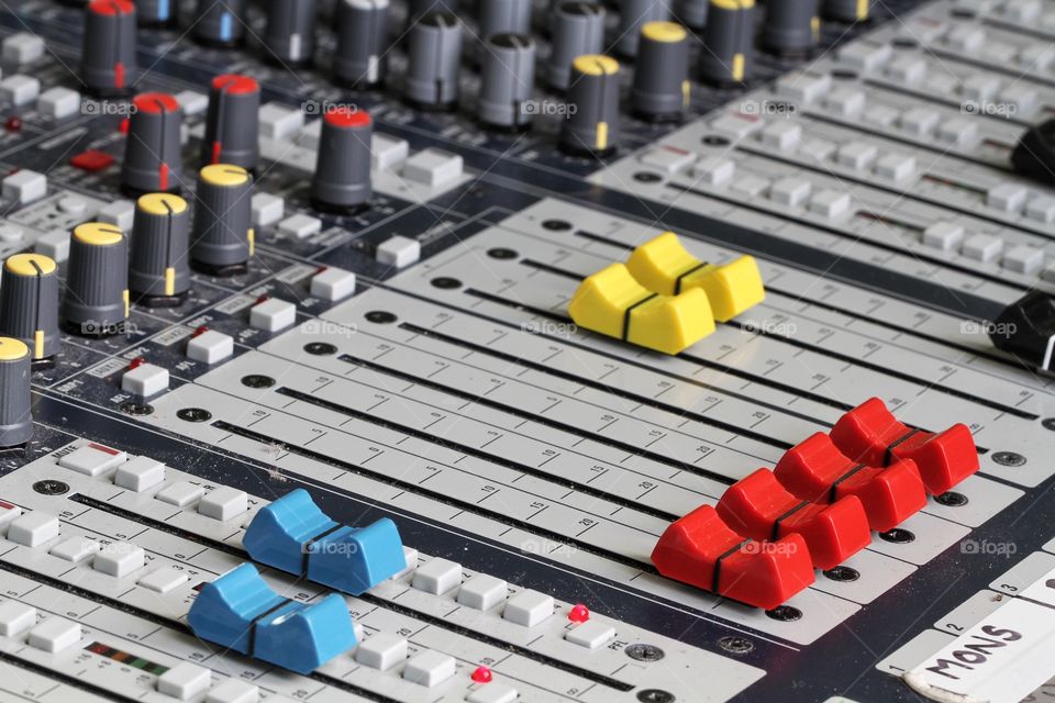 The buttons, sliders and controls of a sound technicians control desk. The lighting and sound control desk used for music concerts and theatre productions.